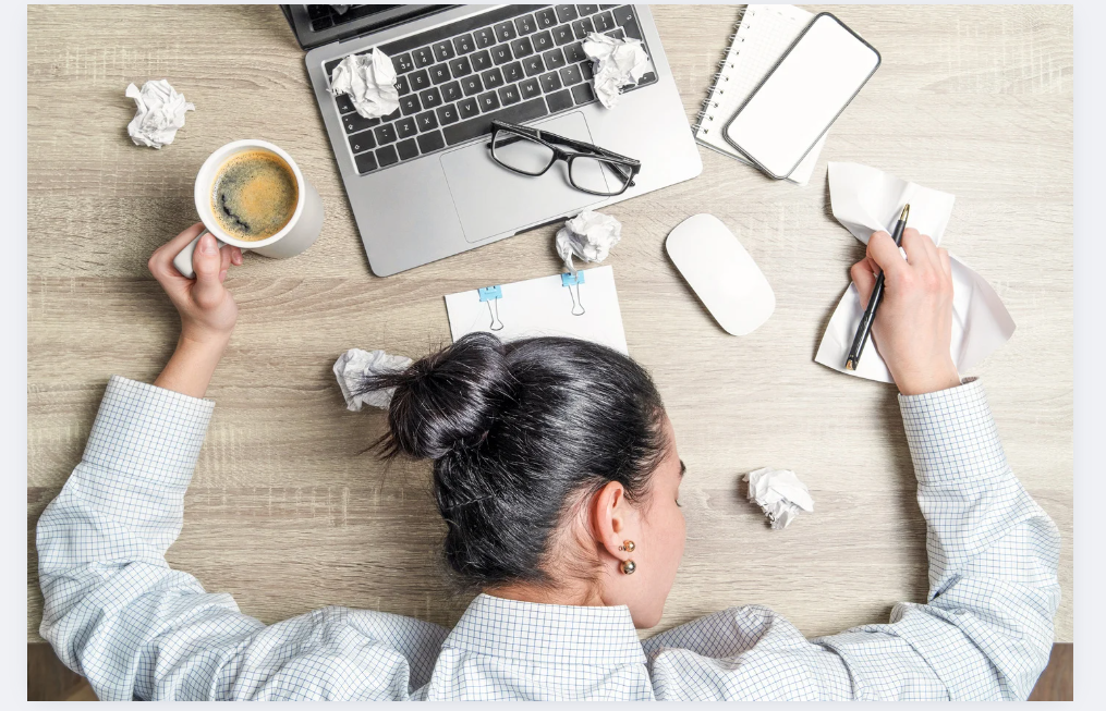 Femme épuisée devant un ordinateur, symbole de fatigue liée au manque de sommeil, au stress ou à une routine de sommeil déséquilibrée.